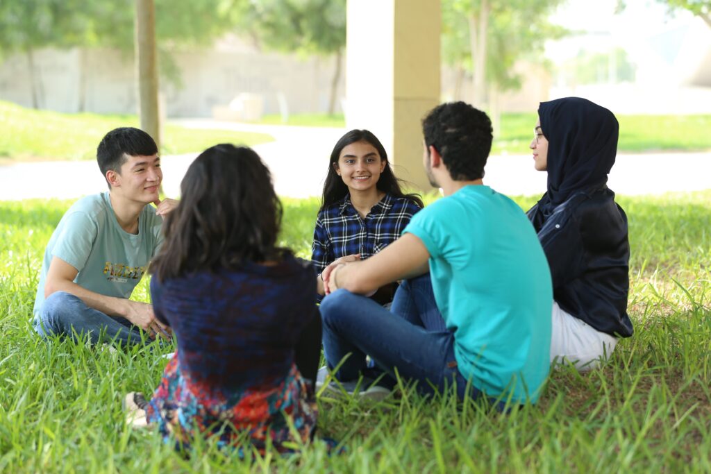 Students sitting together outdoors on campus
