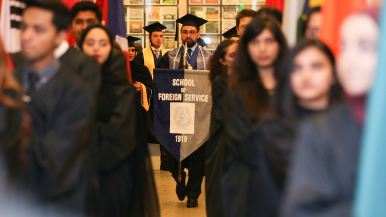 Student holds BSFS flag at the 2019 Commencement Ceremony.
