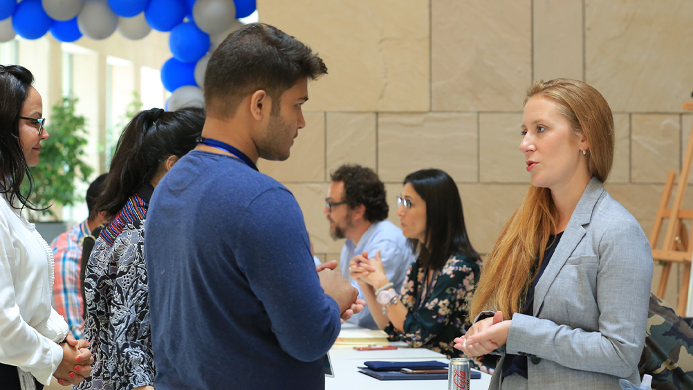 Student speaks to an Academic Services representative at orientation.