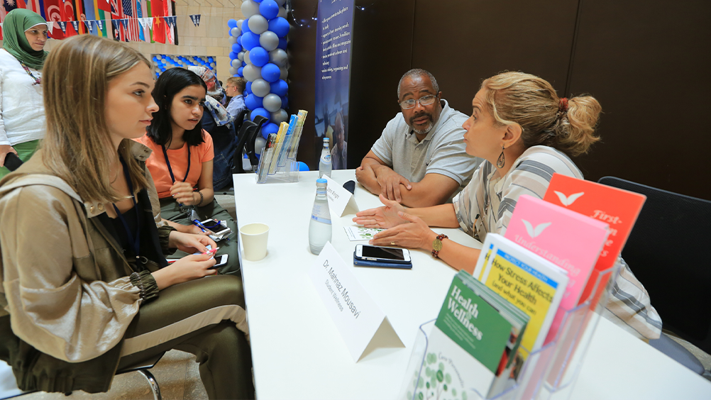 Students speak to a Health and Wellness representatives at orientation.