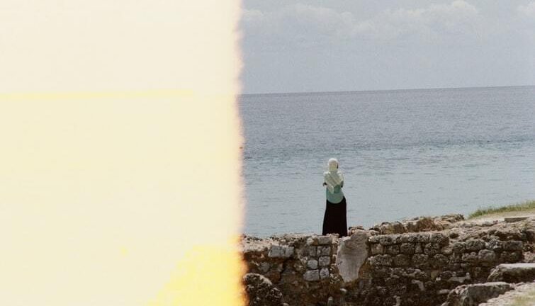 A woman walking along the sea of Zanzibar