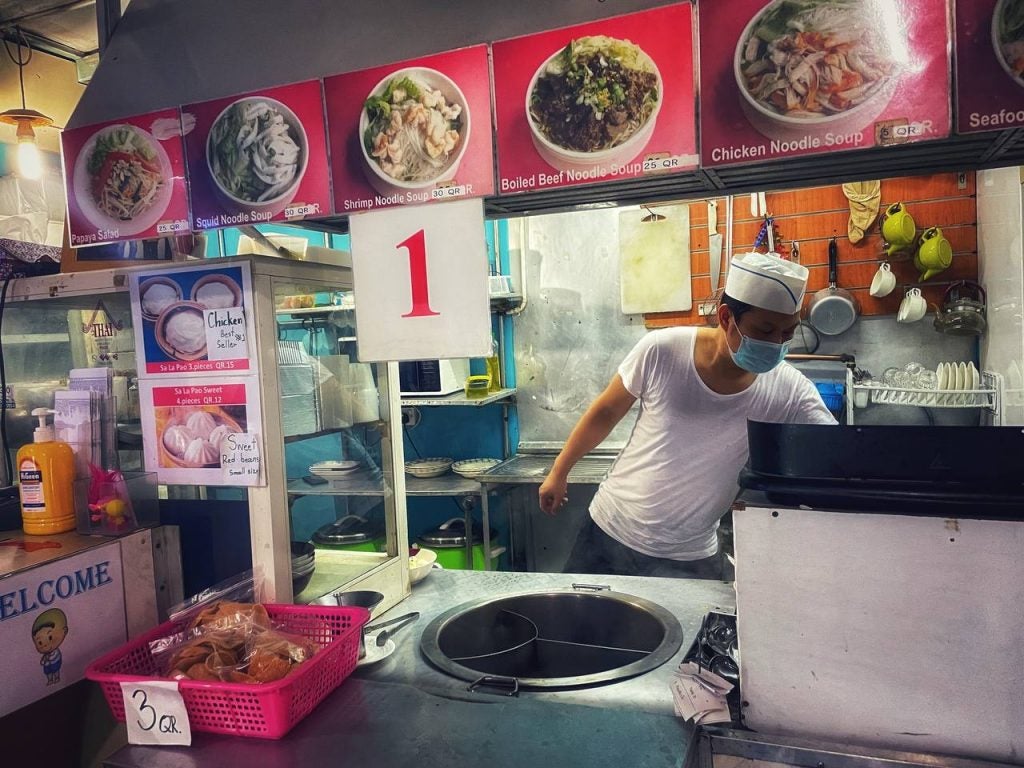 A chef cooking food in the kitchen on display