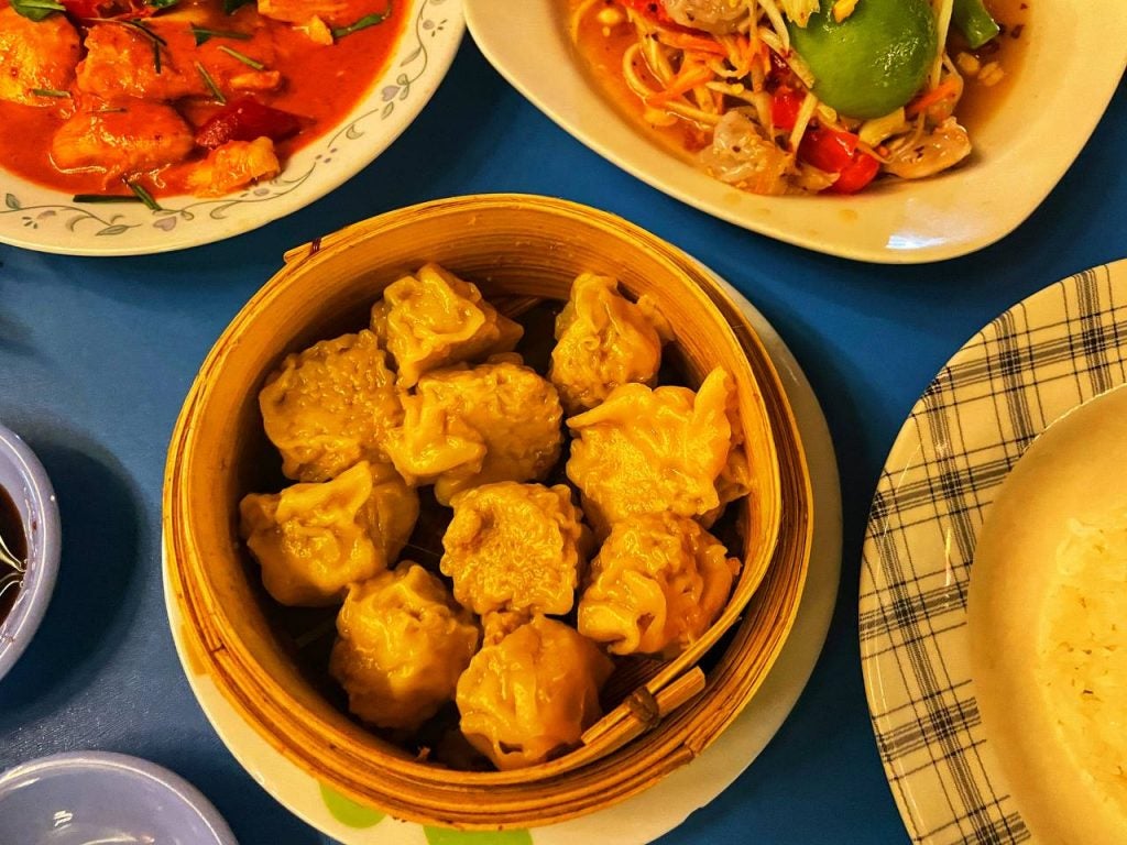 One serving of chicken xiaomai dumplings served in a bamboo bowl