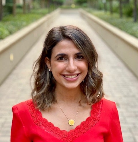 headshot of the speaker (Salma Mousa) in a red dress