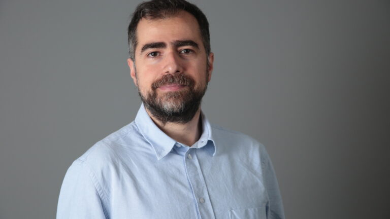 Picture of Mehmet in a light blue collared shirt.