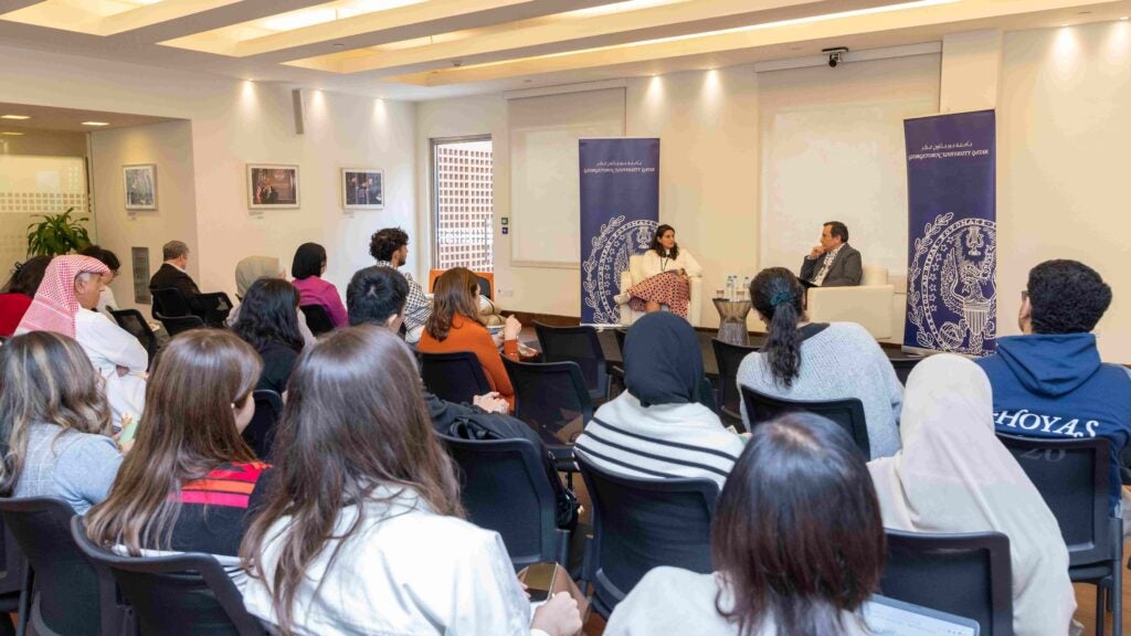 Room full of people with International Lawyer Tamara Essayad talking to Khaled AL-Hroub, Northwestern Qatar